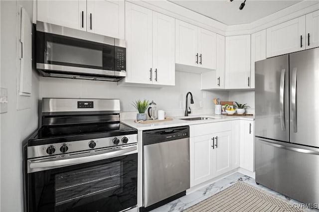 kitchen with appliances with stainless steel finishes, white cabinetry, and sink