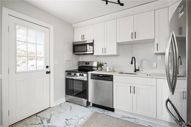 kitchen featuring stainless steel appliances, white cabinetry, and sink