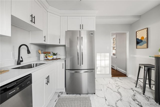 kitchen featuring white cabinets, appliances with stainless steel finishes, a baseboard radiator, and sink