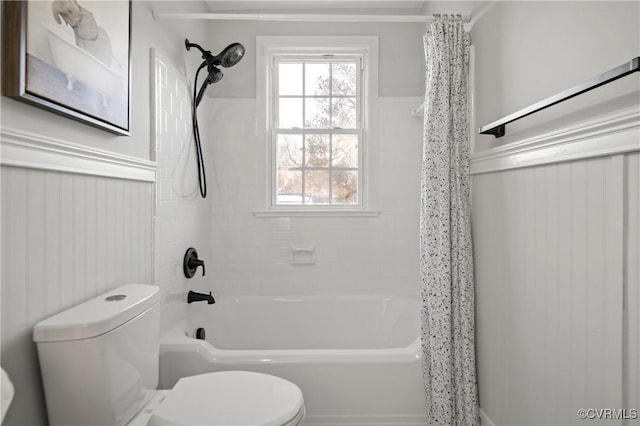 bathroom with toilet, wooden walls, and shower / bath combo