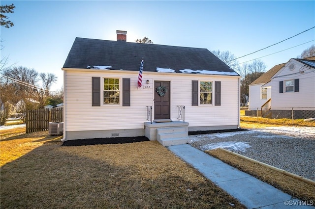 bungalow-style house featuring a front lawn and central AC