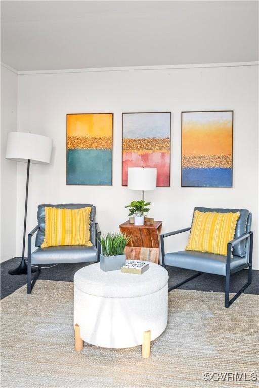 sitting room featuring carpet floors and crown molding