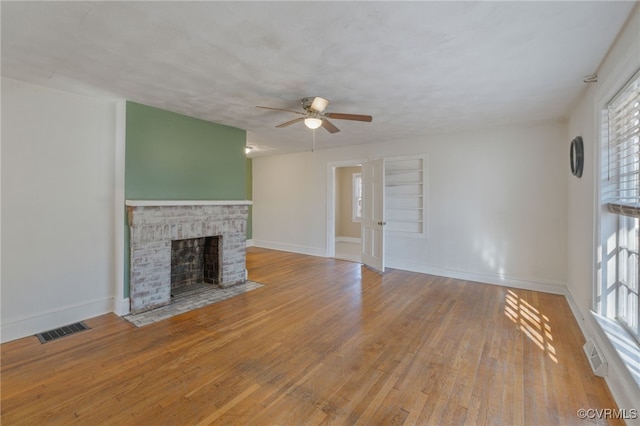 unfurnished living room with light hardwood / wood-style floors, ceiling fan, and a fireplace