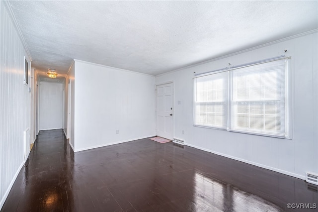 spare room featuring dark hardwood / wood-style floors and a textured ceiling