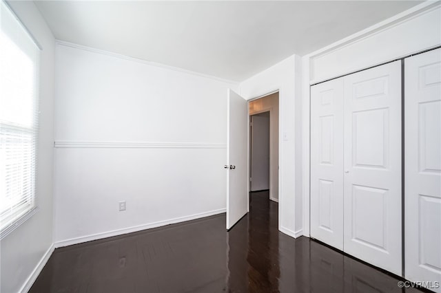 unfurnished bedroom featuring dark hardwood / wood-style floors and a closet