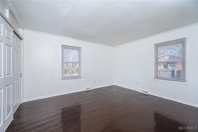 unfurnished bedroom with crown molding, dark wood-type flooring, and a closet