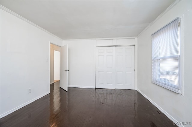 unfurnished bedroom with crown molding, dark hardwood / wood-style flooring, and a closet