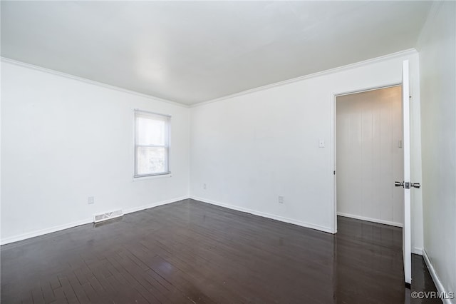 spare room featuring crown molding and dark hardwood / wood-style floors