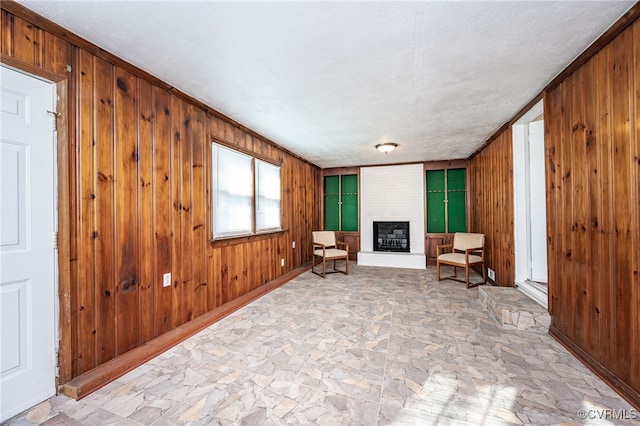 living area featuring a large fireplace and wooden walls