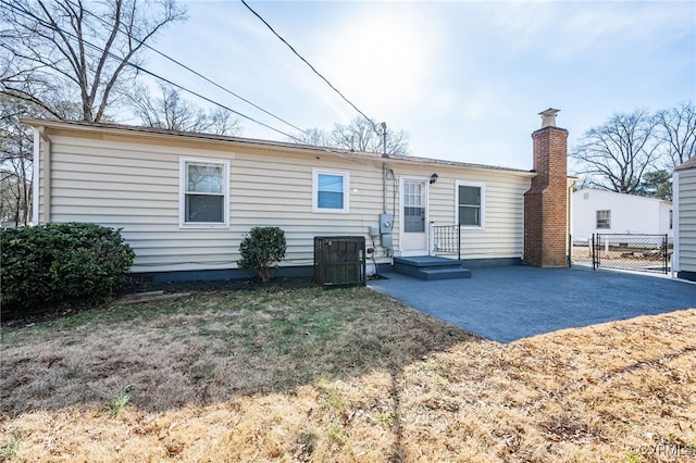 rear view of house with central AC and a patio area