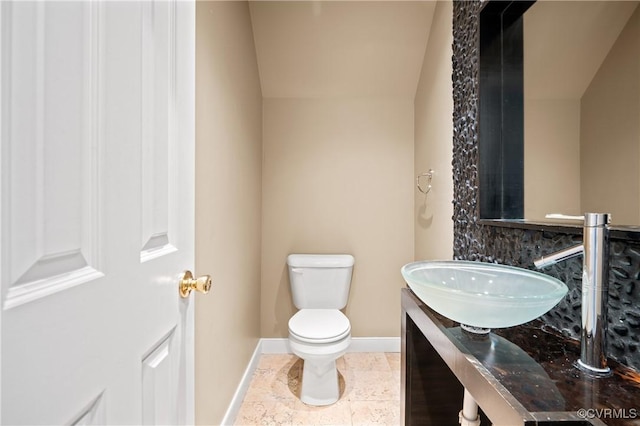 bathroom with toilet, decorative backsplash, and vaulted ceiling