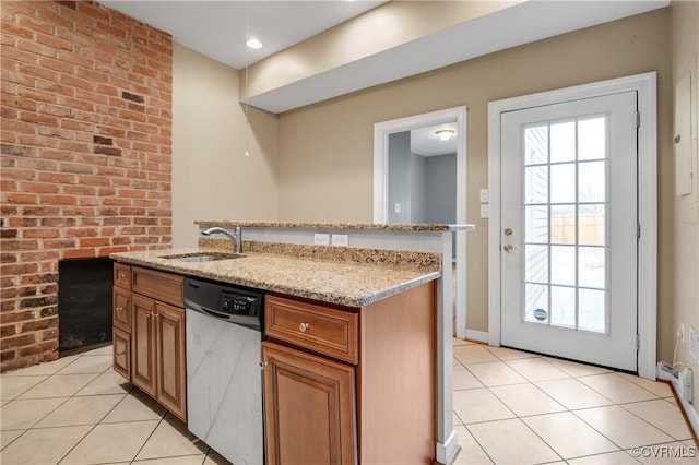 kitchen featuring stainless steel dishwasher, sink, light stone countertops, an island with sink, and light tile patterned floors