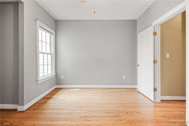 empty room featuring a healthy amount of sunlight and light hardwood / wood-style floors