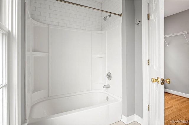 bathroom featuring wood-type flooring and bathing tub / shower combination