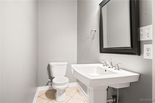 bathroom featuring toilet, tile patterned flooring, and sink