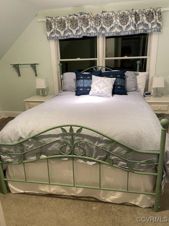 bedroom featuring vaulted ceiling and carpet