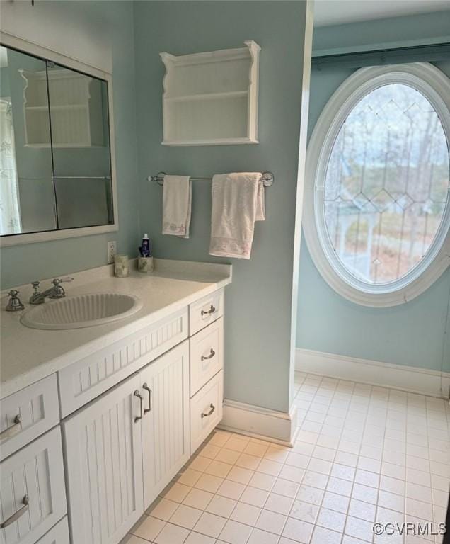 full bathroom with tile patterned flooring, vanity, and baseboards