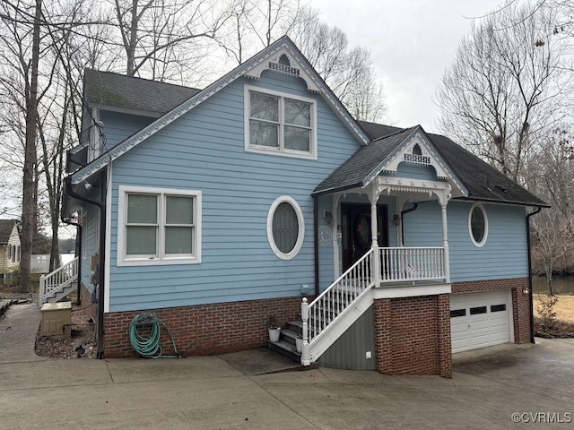 victorian home featuring driveway, an attached garage, a shingled roof, and brick siding