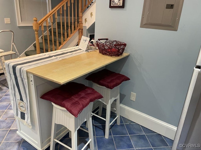 interior space with stairs, electric panel, and baseboards