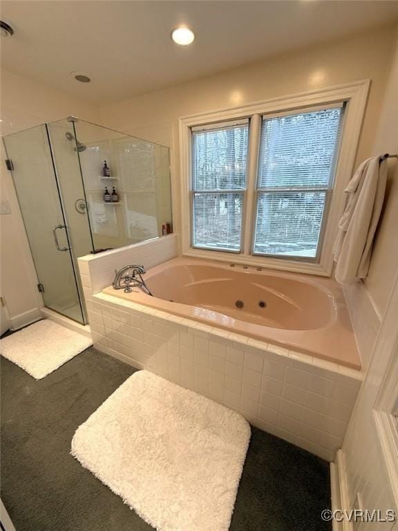 bathroom featuring a tub with jets, a stall shower, and recessed lighting