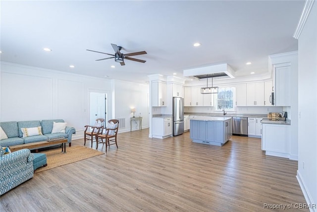 living room with ceiling fan, light hardwood / wood-style floors, and crown molding