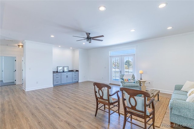 living room with ceiling fan, light wood-type flooring, french doors, and crown molding