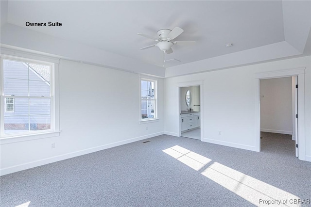 carpeted spare room featuring a healthy amount of sunlight and ceiling fan