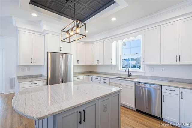 kitchen with sink, stainless steel appliances, a center island, and white cabinets