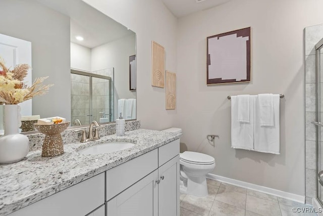 bathroom with toilet, vanity, tile patterned floors, and a shower with shower door