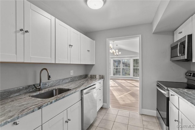 kitchen featuring light tile patterned floors, stainless steel appliances, white cabinetry, and sink