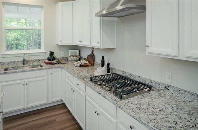 kitchen featuring sink, stainless steel gas cooktop, white cabinets, and range hood