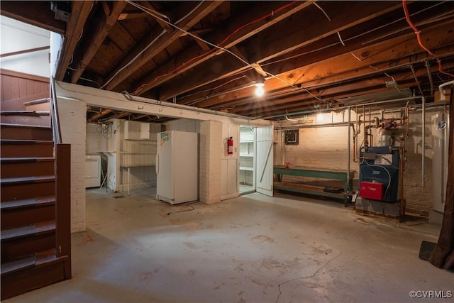 basement with washer / clothes dryer and white refrigerator