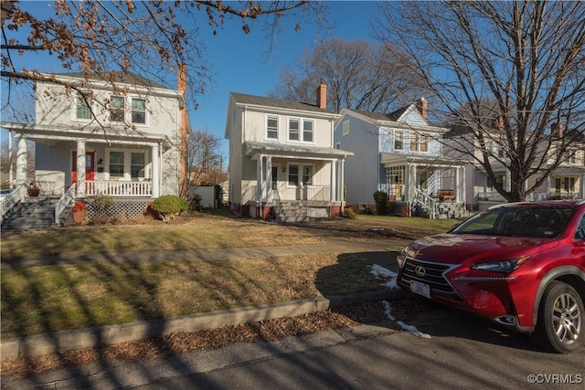 view of property featuring a porch and a front lawn