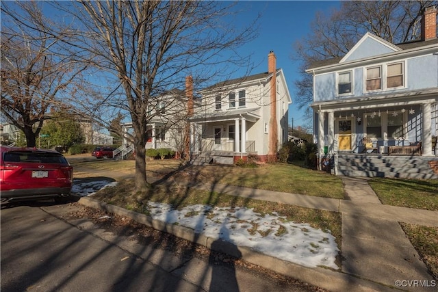 view of front of home with covered porch and a front lawn