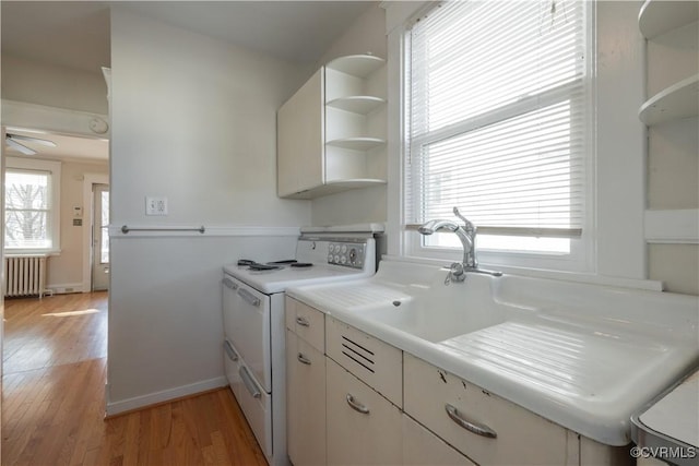 kitchen with white electric range oven, ceiling fan, light hardwood / wood-style floors, and radiator heating unit