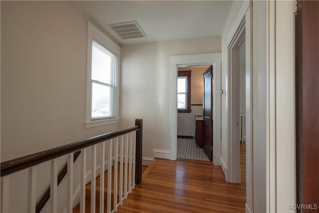 corridor with tile walls and hardwood / wood-style floors