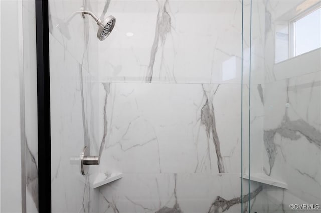 interior details featuring a marble finish shower