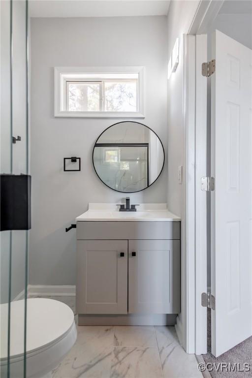 bathroom featuring toilet, marble finish floor, and vanity