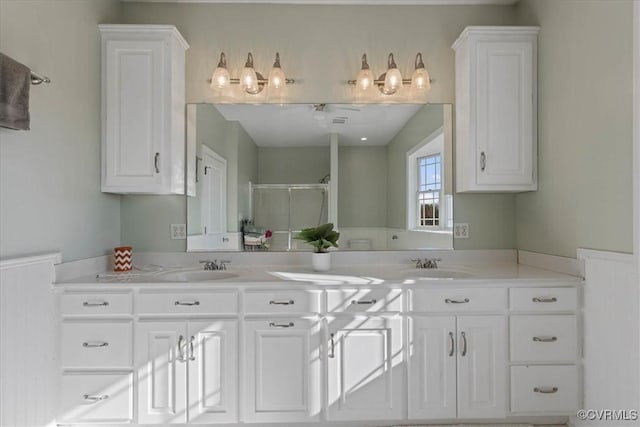 kitchen featuring ceiling fan, sink, and white cabinets