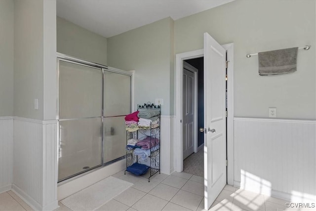 bathroom with tile patterned flooring and a shower with shower door