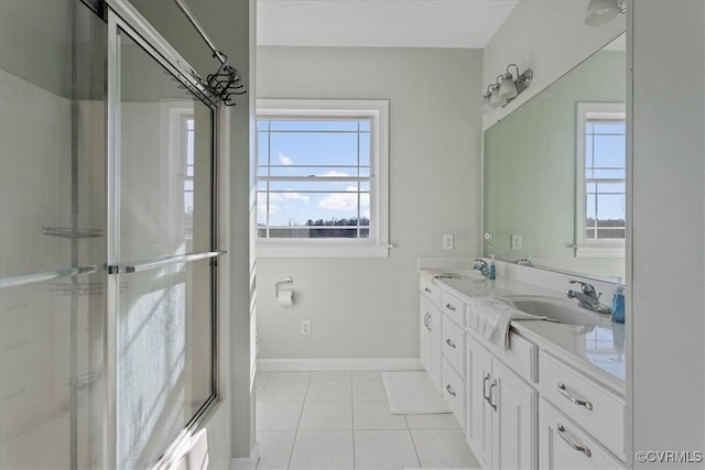 bathroom featuring tile patterned flooring, vanity, bath / shower combo with glass door, and a healthy amount of sunlight