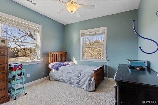 carpeted bedroom featuring ceiling fan and multiple windows