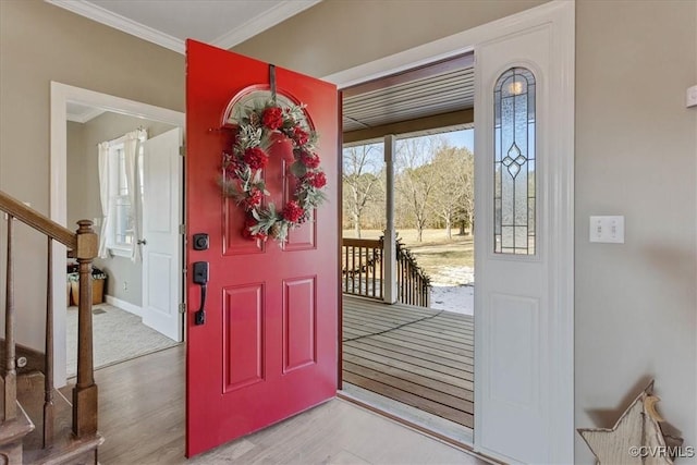 entrance foyer with crown molding and light hardwood / wood-style floors