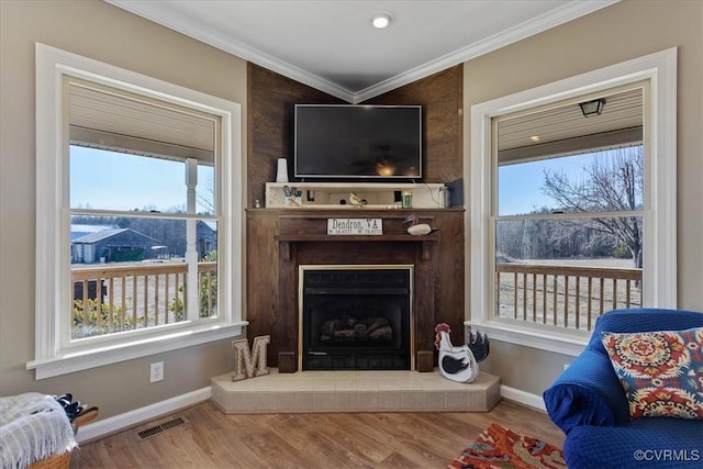 living room with ornamental molding, a healthy amount of sunlight, and hardwood / wood-style floors