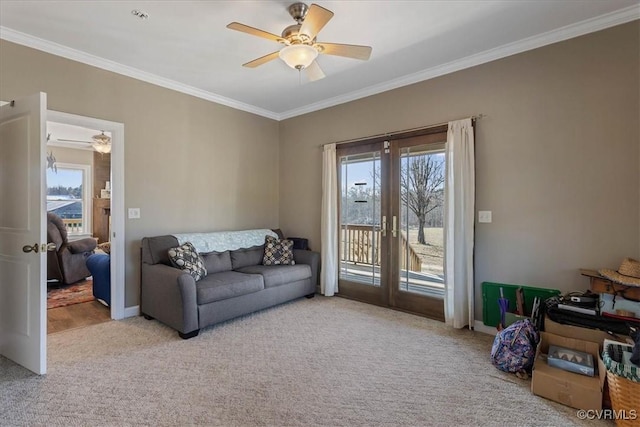 carpeted living room with ornamental molding and ceiling fan