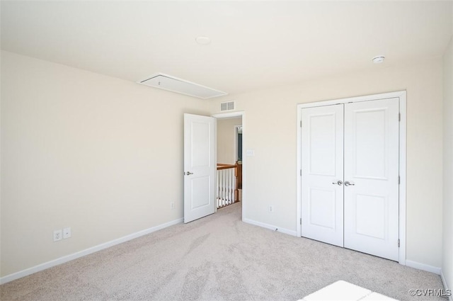 unfurnished bedroom featuring light colored carpet and a closet