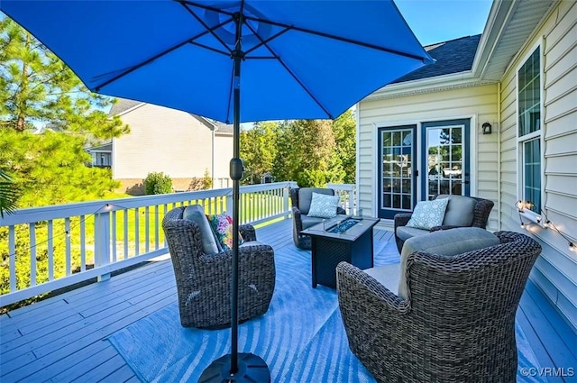 wooden terrace with an outdoor living space with a fire pit