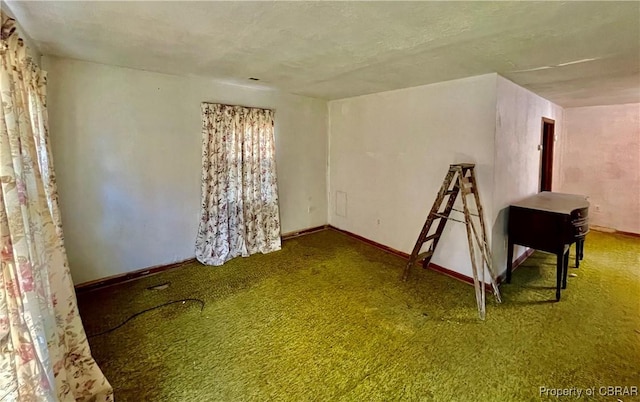 empty room featuring a textured ceiling and carpet