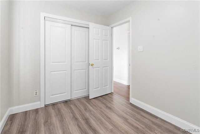 unfurnished bedroom with light hardwood / wood-style floors and a closet