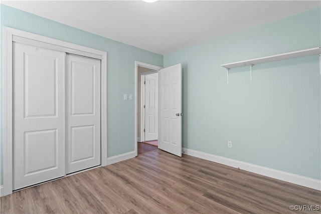 unfurnished bedroom featuring hardwood / wood-style flooring and a closet